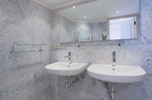 a white bathroom with two sinks and a mirror at EMPIRIC Keizersgracht in Amsterdam