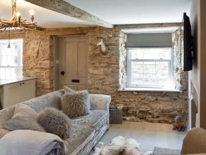 a living room with a couch and a stone wall at no 8 main street in Sedbergh