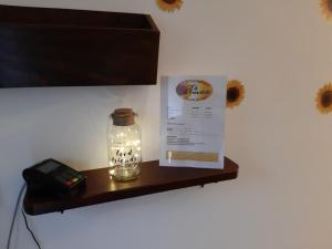 um frasco com uma luz numa prateleira com um telefone em CA' VIRASOLELH em Macra