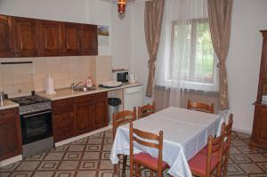Vuksanovic Apartment في هرسك نوفي: مطبخ مع طاولة وكراسي ومغسلة
