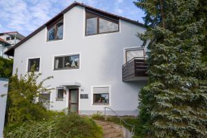 una casa blanca con un árbol en Das Nest am Wohrenberg en Daisendorf