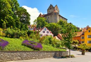 uma cidade com um castelo numa colina com flores roxas em Das Nest am Wohrenberg em Daisendorf