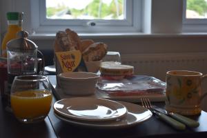 a table with a breakfast of bread and orange juice at Boatyard View in Sandwich