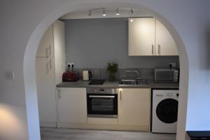 an archway in a kitchen with a stove and microwave at Boatyard View in Sandwich