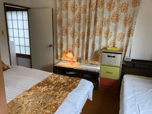 a hotel room with two beds and a desk with a desk at kyoka house練馬 in Tokyo +35 photos