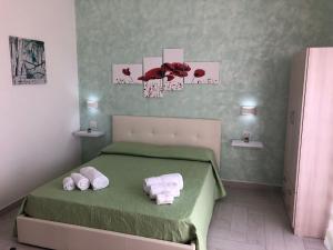 um quarto com uma cama verde e toalhas em RESIDENZA IL CREMINO em Tropea