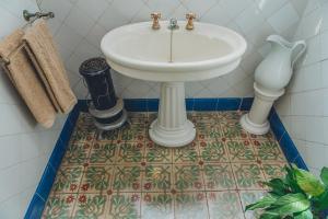 uma casa de banho com lavatório e piso em azulejo em Casa Baulenas em Caldes d'Estrac