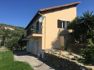 dom z kamienną ścianą przed nim w obiekcie Agriturismo Oltrealmare w mieście Civezza