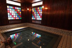 Fujiya في كجا: غرفة مع حمام سباحة ونوافذ زجاجية ملطخة