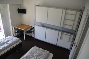 Schlafzimmer mit einem Bett, einem Schreibtisch und einer Glaswand in der Unterkunft Nykøbing Falster Vandrehjem in Nykøbing Falster