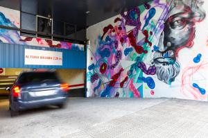un coche pasando una pared con un cuadro. en Spirit Hotel Gran Bilbao, en Bilbao