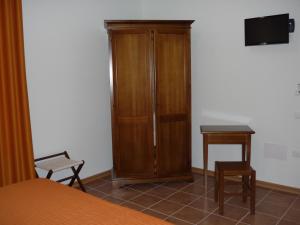 a bedroom with a wooden cabinet and a table at Agriturismo Ai Laghi in Pocenia