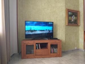 TV de pantalla plana en la parte superior de un centro de entretenimiento de madera en Luxury Flat, en Málaga