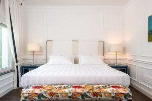 una camera con un grande letto bianco e due lampade di Casa tua Spa Resort a Porto Recanati