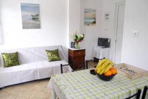 a living room with a table with a bowl of bananas at Marathona's Apartment in Aegina Town