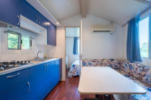 kuchnia z niebieskimi szafkami i kanapą w obiekcie Camping Vicenza w mieście Vicenza +24 zdjęcia