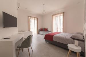 a white bedroom with a bed and a desk and a desk at B&B Napoli Centro in Naples