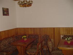 - un salon avec un canapé, une table et des chaises dans l'établissement Pension Baron, à Vrchlabí