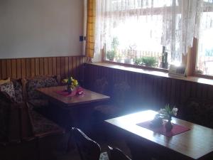a room with two tables and two windows at Pension Baron in Vrchlabí
