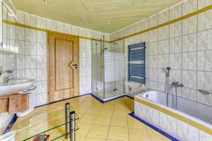 a bathroom with a tub and a sink at Ferienwohnung Barth in Tittling +7 photos