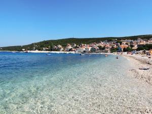 a beach with a group of people in the water at Car free island Unije Gasparini apartments in Unije