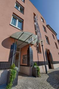 un edificio con una sombrilla delante de él en Business & Art Hotel Markgraf, en Emmendingen