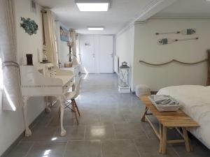 a bedroom with a desk and a bed and a table at Sur la route des peintres in Champagne-sur-Oise