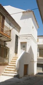 a white building with stairs leading to a door at BORGO PETELIA, Casa Castiglione, Antica casa su due piani con scala esterna in Strongoli