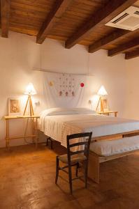 a bedroom with a bed and a chair in a room at BORGO PETELIA, Casa Castiglione, Antica casa su due piani con scala esterna in Strongoli