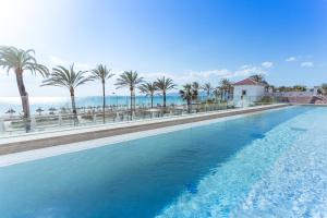 einen großen Pool mit Palmen und dem Meer in der Unterkunft Myseahouse Flamingo - Adults Only 4* Sup in Playa de Palma