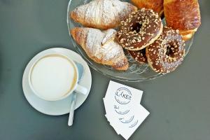 a table with a plate of donuts and a cup of coffee at B&B I LAKE IT BELLAGIO in Bellagio