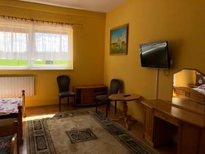 Setpol 1 في Wyszomierz: غرفة بها كرسيين وتلفزيون على الحائط