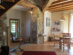 a living room with a table and a stone wall at La Haute Gilberdière in Sartilly