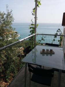 uma mesa e cadeiras numa varanda com o oceano em Qeparo Antonio Rooms em Qeparo
