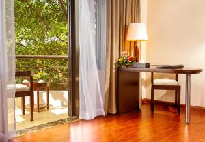 a desk with a lamp in a room with a window at Garco Dragon Hotel in Hanoi