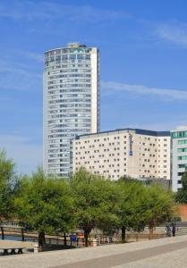 a tall building with trees in front of it at Radisson Blu Hotel, Liverpool in Liverpool