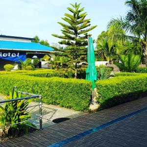 Un ombrello verde seduto sul lato di una strada di Bis Hotel ad Abomey