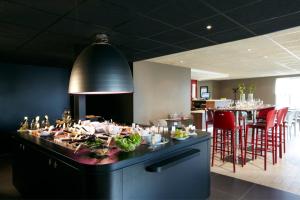 un restaurante con una mesa con comida. en Campanile Brest - Gouesnou Aeroport en Brest