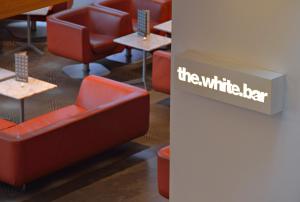 a waiting room with red chairs and tables and a sign at Radisson Blu Hotel, Liverpool in Liverpool