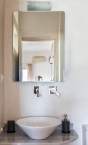 een badkamer met een wastafel en een spiegel bij Sitia Old Port Studio in Sitia