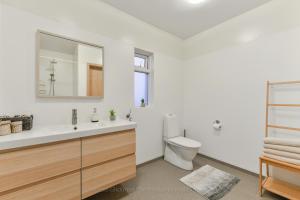 a white bathroom with a sink and a toilet at Syðra-Skörðugil Guesthouse in Varmahlid