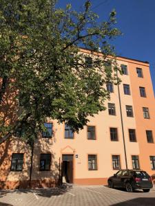 un gran edificio naranja con un coche aparcado delante en Pernavas Park & Bed Apartment Riga, en Riga