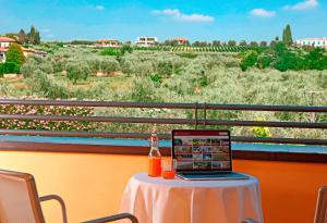 a laptop sitting on a table with a view of a field at Hotel Caesius Thermae & Spa Resort in Bardolino