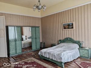 um quarto com uma cama e um espelho em Kakukk Panzió em Nyírbátor