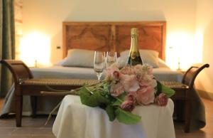 un tavolo con una bottiglia di champagne e due bicchieri di La Corte Delle 4 Stagioni a Ozzano Monferrato