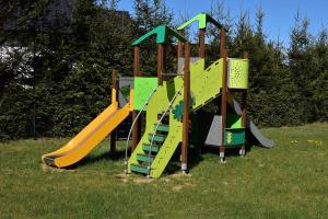 a playground with a slide in the grass at Domki Letniskowe Zielony Zakątek in Ustka