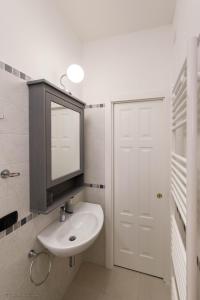 ein weißes Badezimmer mit einem Waschbecken und einem Spiegel in der Unterkunft C'era Un Lago in Avezzano