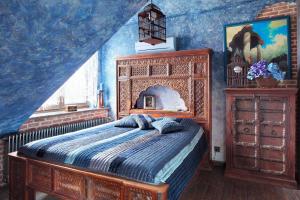 a bedroom with a bed in a blue room at Attic Apartment Warszawa in Warsaw