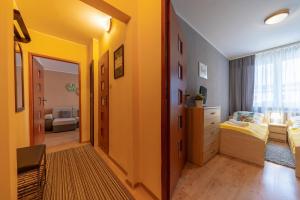 シュクラルスカ・ポレンバにあるRentPlanet - Apartamenty 1 Majaの黄色の壁のベッドルーム1室、ベッド1台、ドレッサーが備わります。
