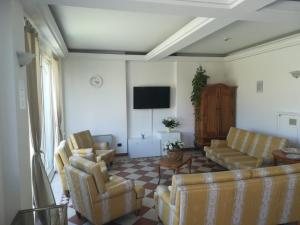 uma sala de estar com sofás e uma televisão de ecrã plano em Residenza Villa Margherita em Rimini